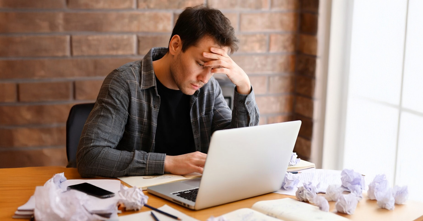 hombre estudiando solo frustrado frente a la pantalla de la computadora